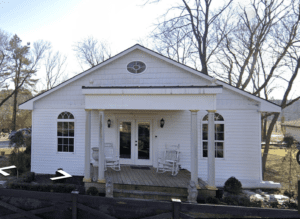 White house with porch and rocking chairs.